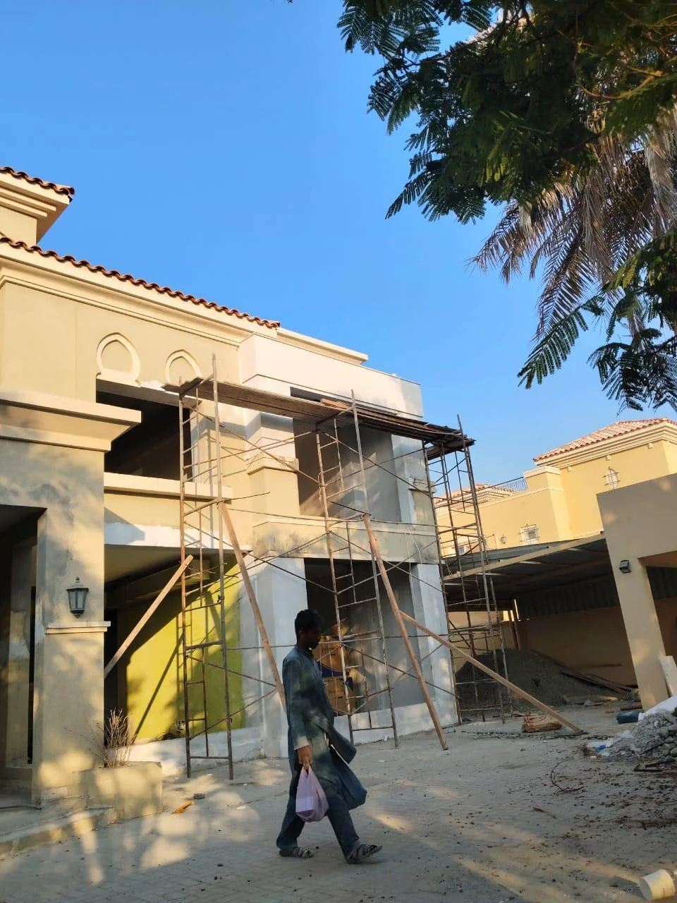 مدخل مبنى مع سقالات ومواد أعمال